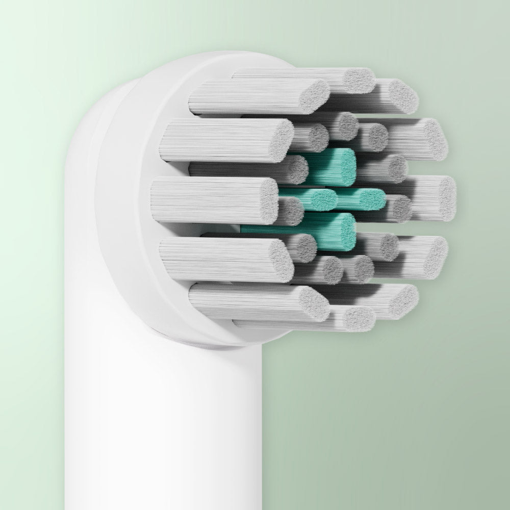 Close-up of the Rev white brush head refill with soft gray and teal bristles.