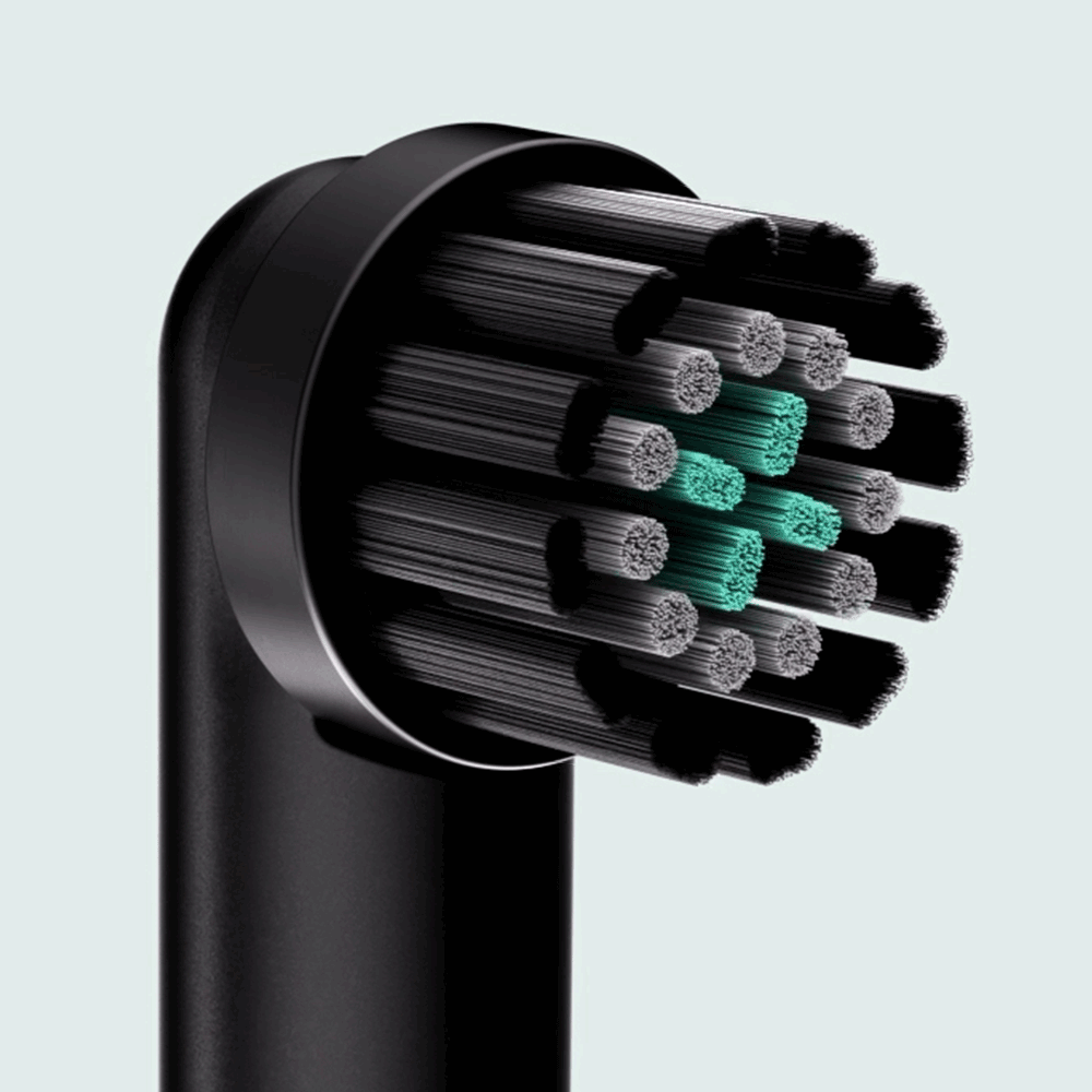 A close-up of a black quip Rev brush head refill, featuring black and grey bristles with a central cluster of teal indicator bristles.