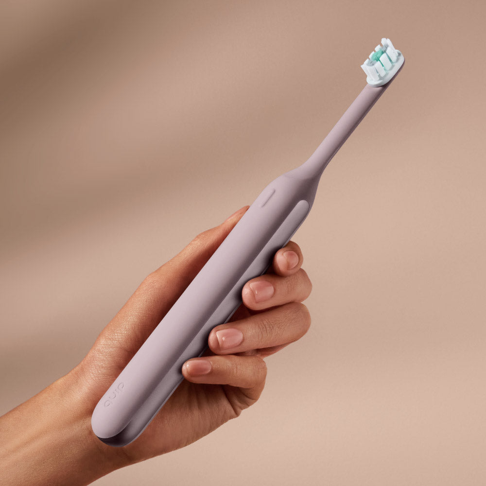 Hand holding the Ultra™ Next Generation Smart Sonic Electric Toothbrush in Dusk color.