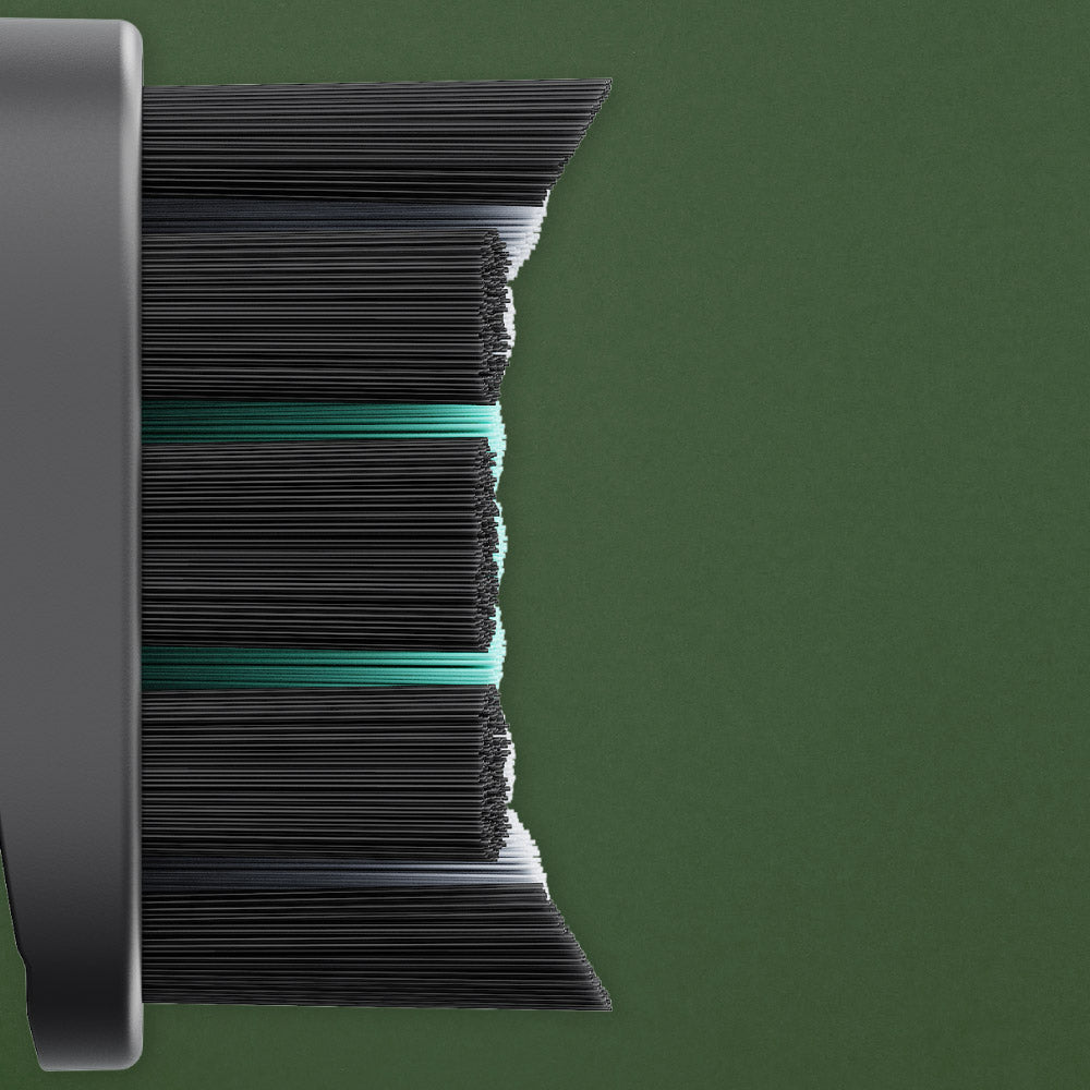 Close-up of a hairbrush with black bristles on a green background