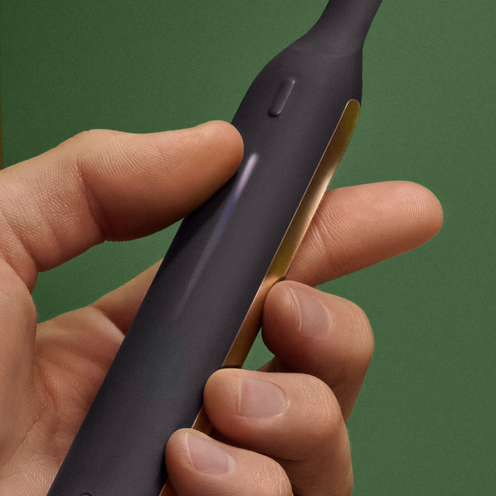 Hand adjusting power on the Ultra™ toothbrush using the dynamic LED touch bar, offering 10+ levels of personalized power.