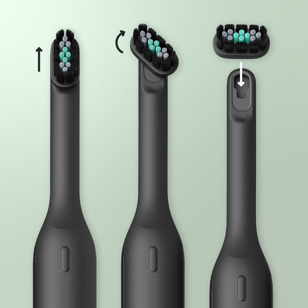 Black electric toothbrush with interchangeable heads on a light green background