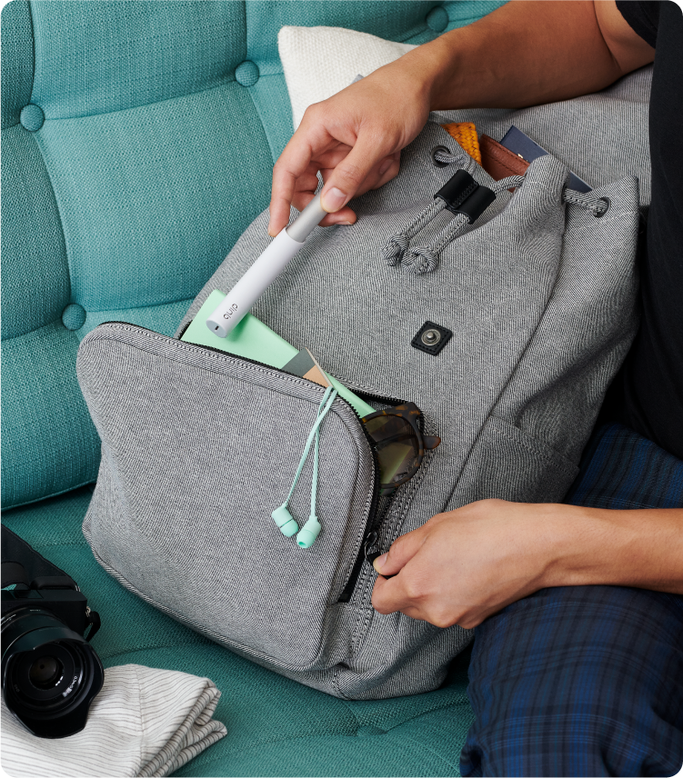 a model is inserting the quip Sonic Toothbrush into the pocket of his backpack