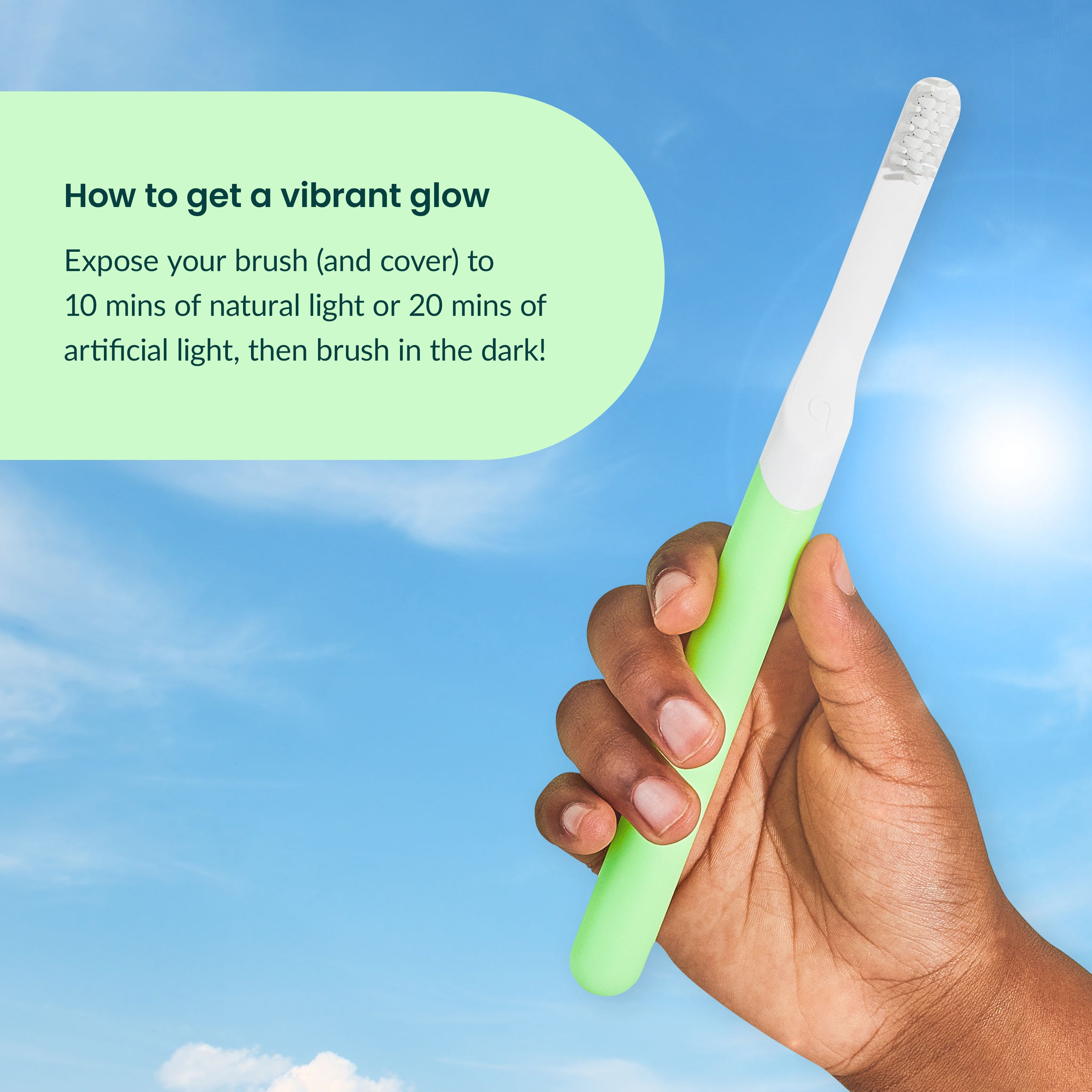 A hand holding a green quip Kids Sonic toothbrush against a bright blue sky, with a text box explaining how to make the glow stronger.
