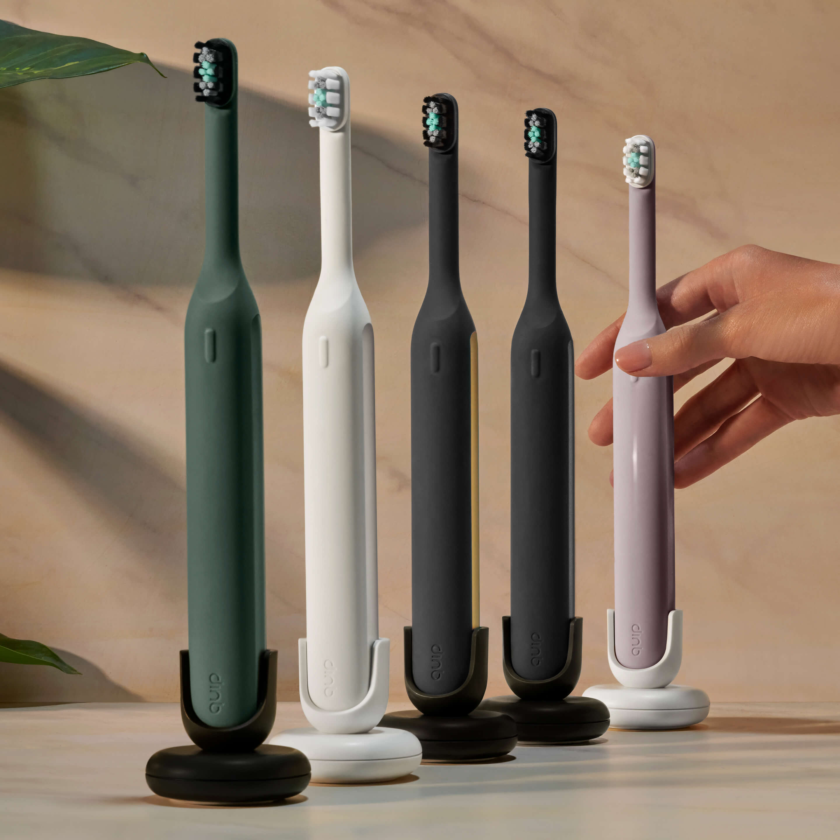 Ultra™ Smart Sonic Electric Toothbrushes in various colors on stands, with a hand reaching for one.