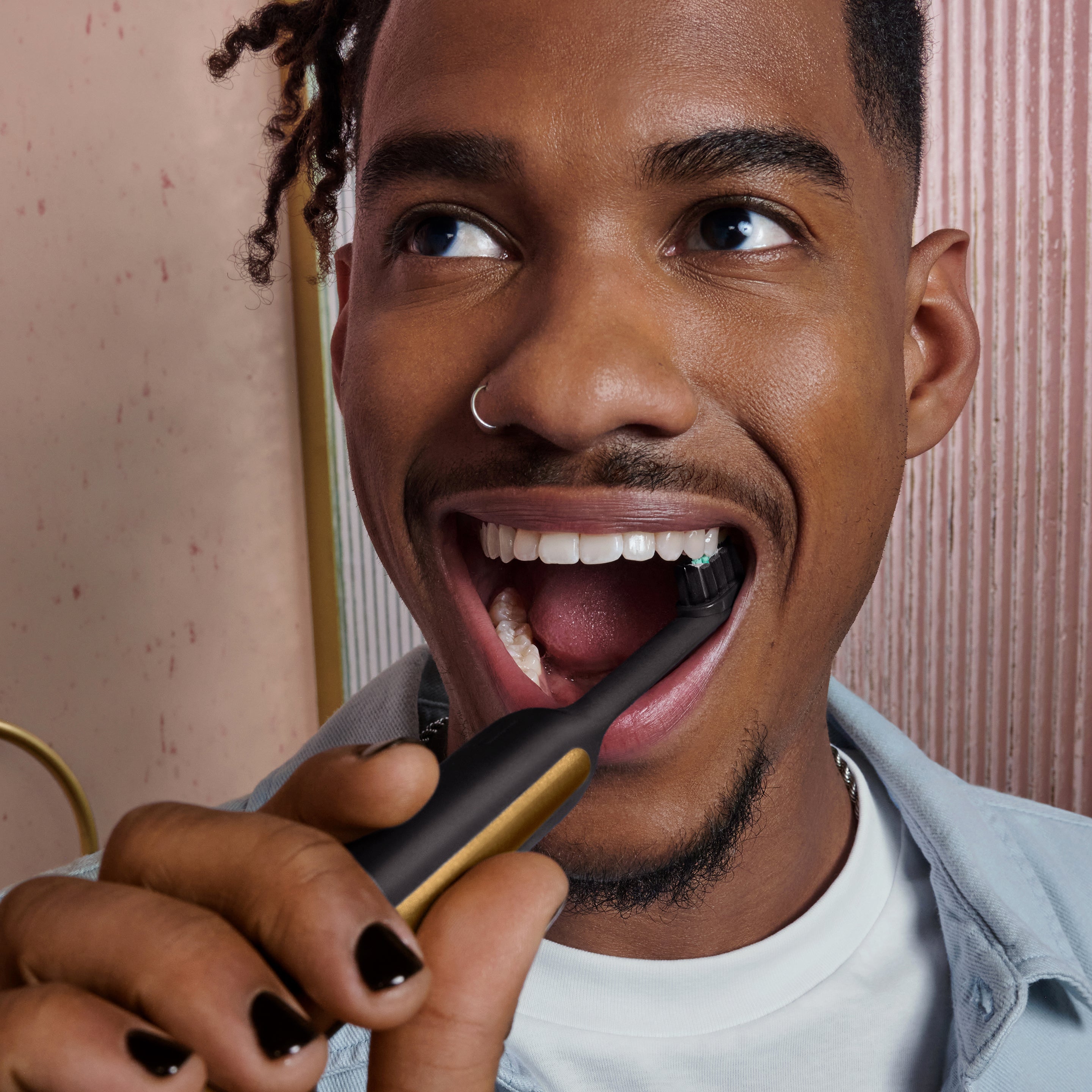 Person brushing their teeth with the Ultra™ Next Generation Smart Sonic Electric Toothbrush in Eclipse color, featuring a sleek black and gold design.