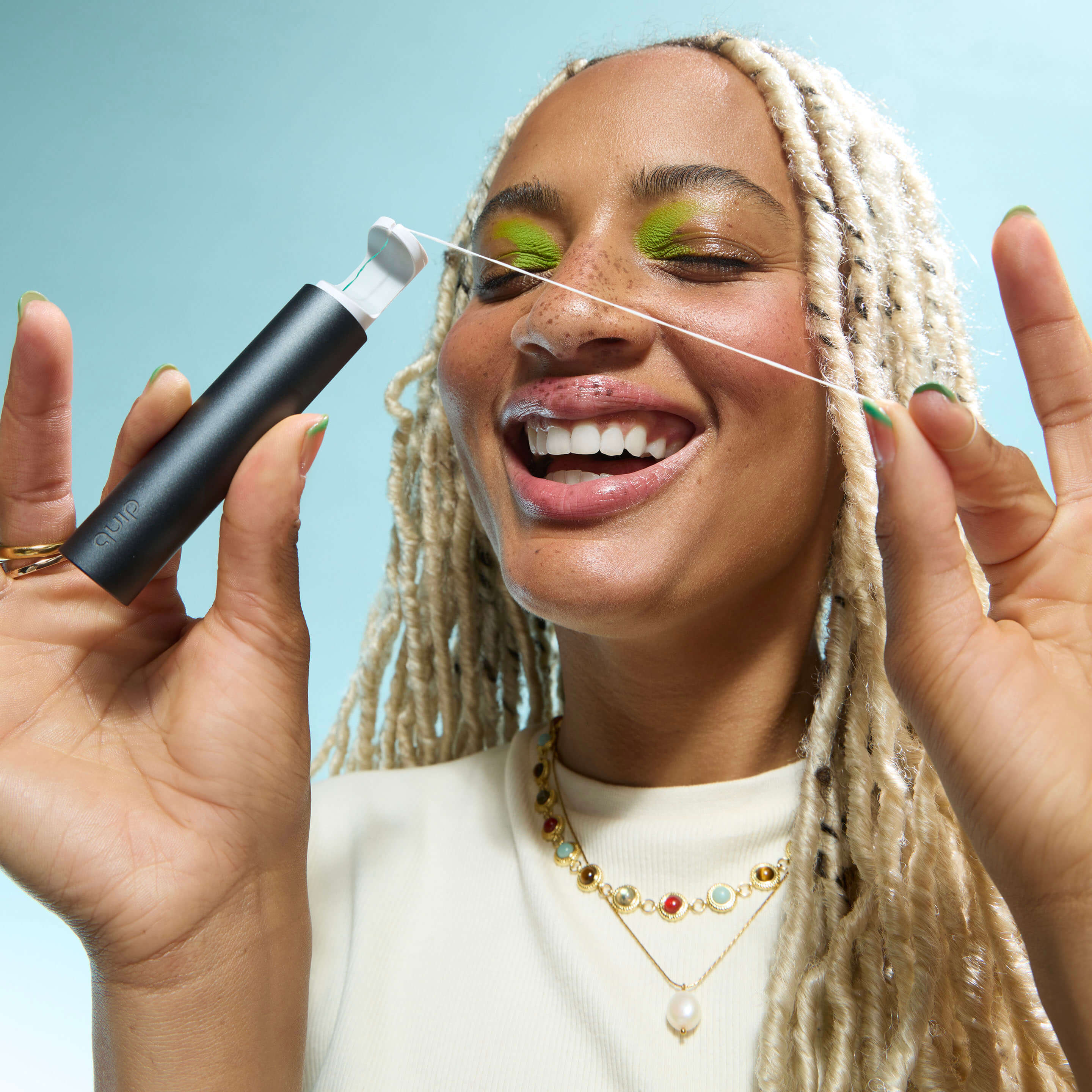Woman using a threading tool with a blue background