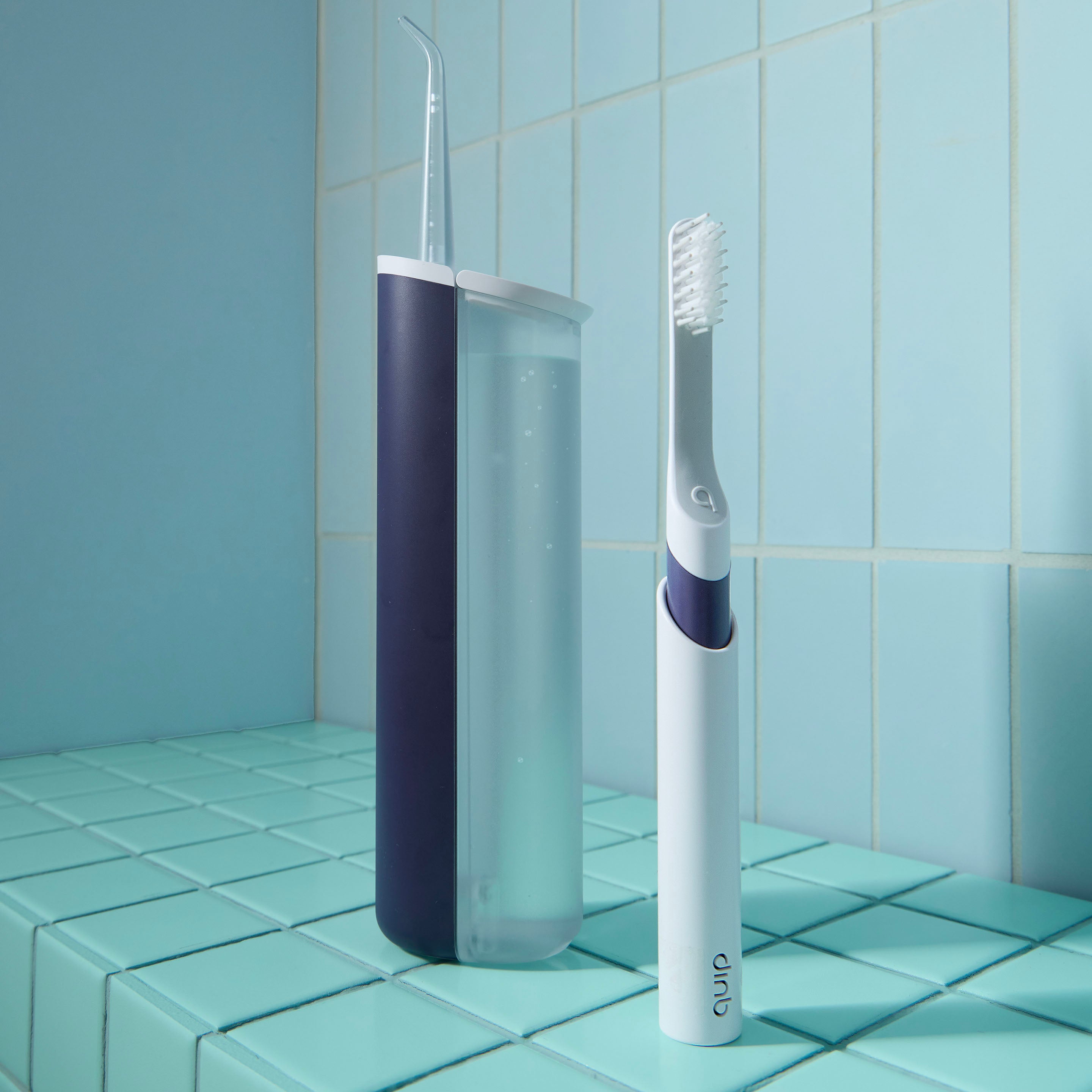 Electric toothbrush with a purple handle on a tiled bathroom floor.