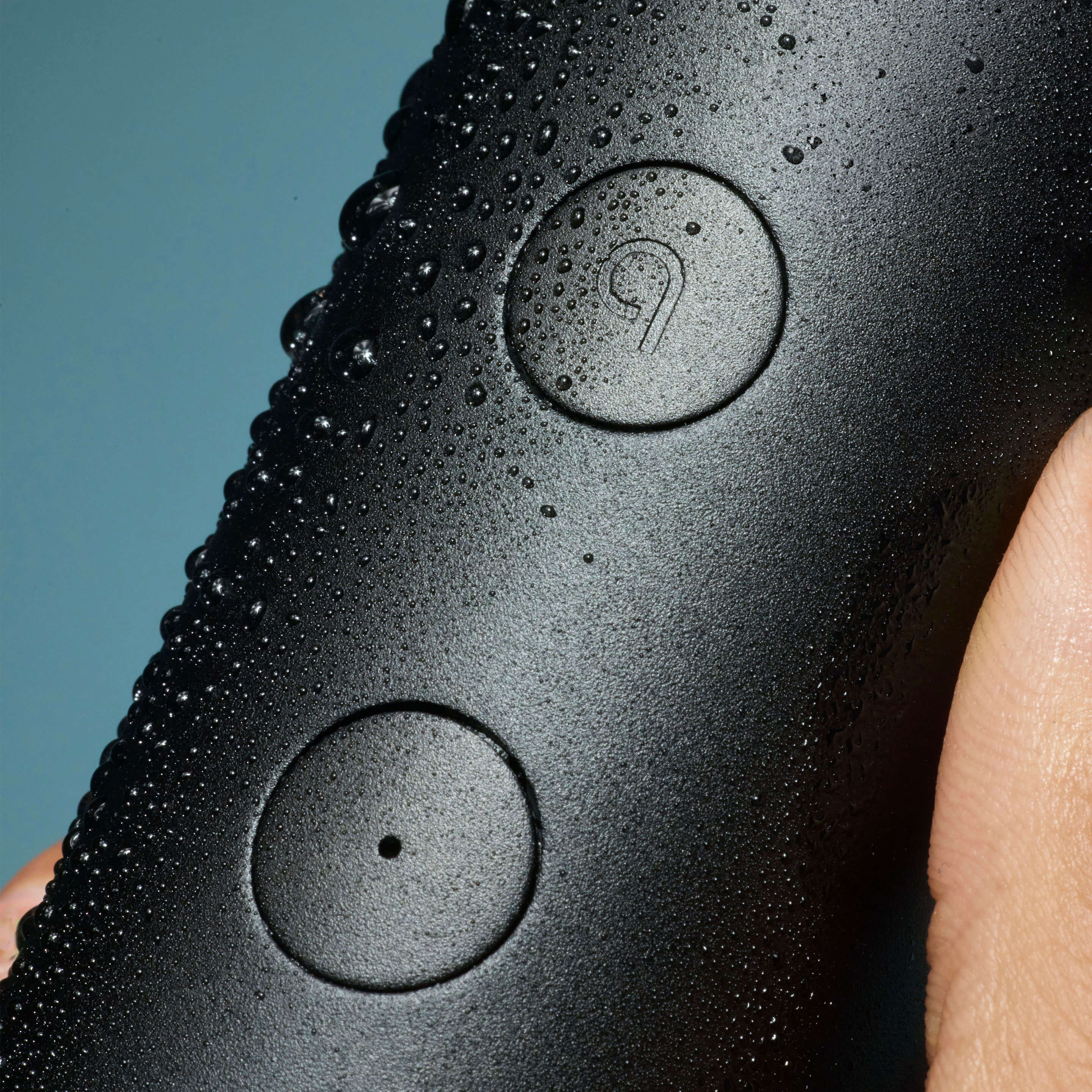 Black electronic device with water droplets on a blue background