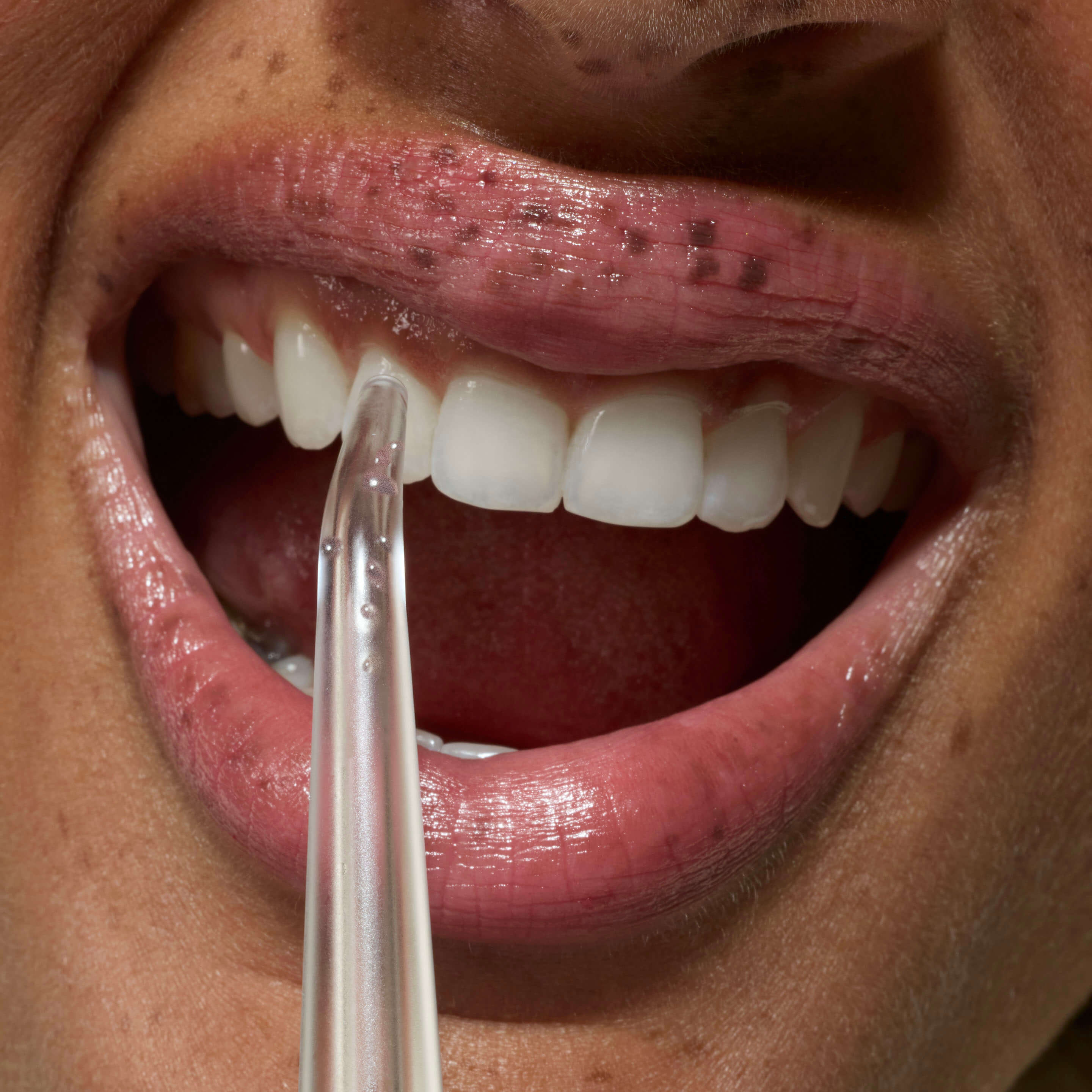 Close-up of a person using a dental floss threader.