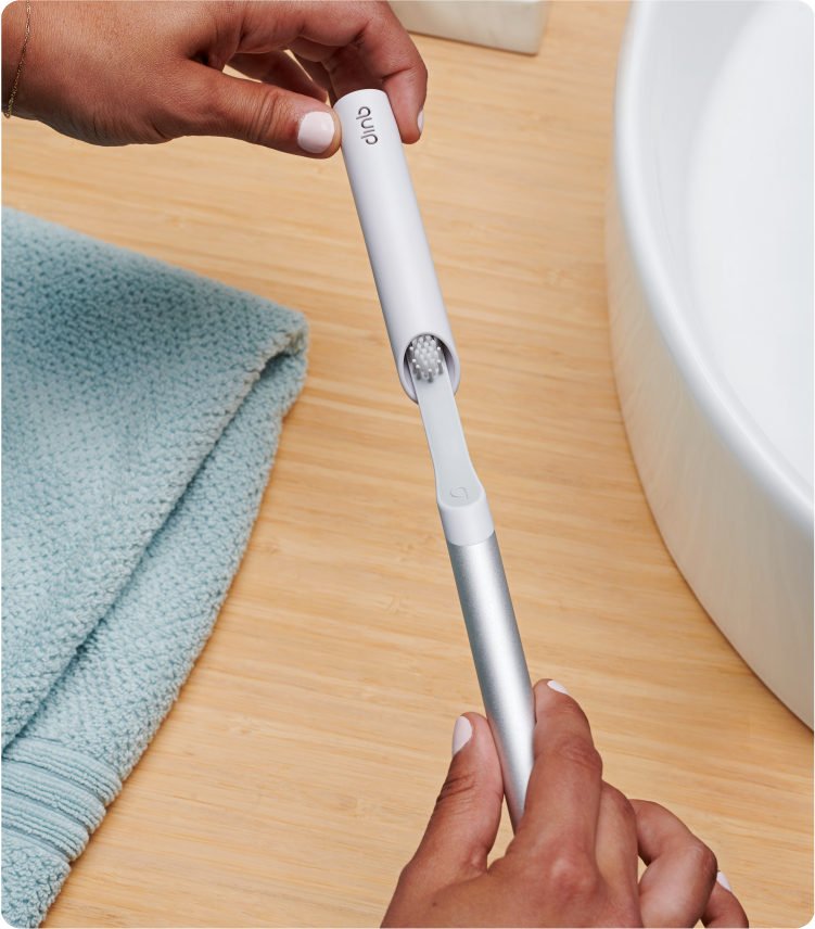 a model covering her quip sonic toothbrush with the quip travel cover that can also serve as a mount