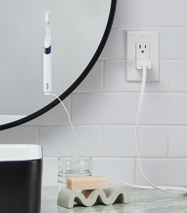 quip Sonic Rechargeable Toothbrush mounted on the bathroom mirror while getting charged