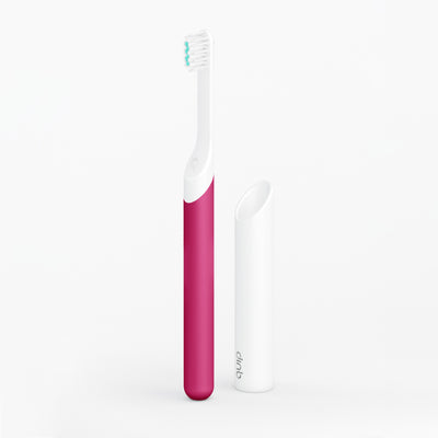 A kids sonic toothbrush with a pink handle and white brush head, displayed alongside its travel cover/mount.