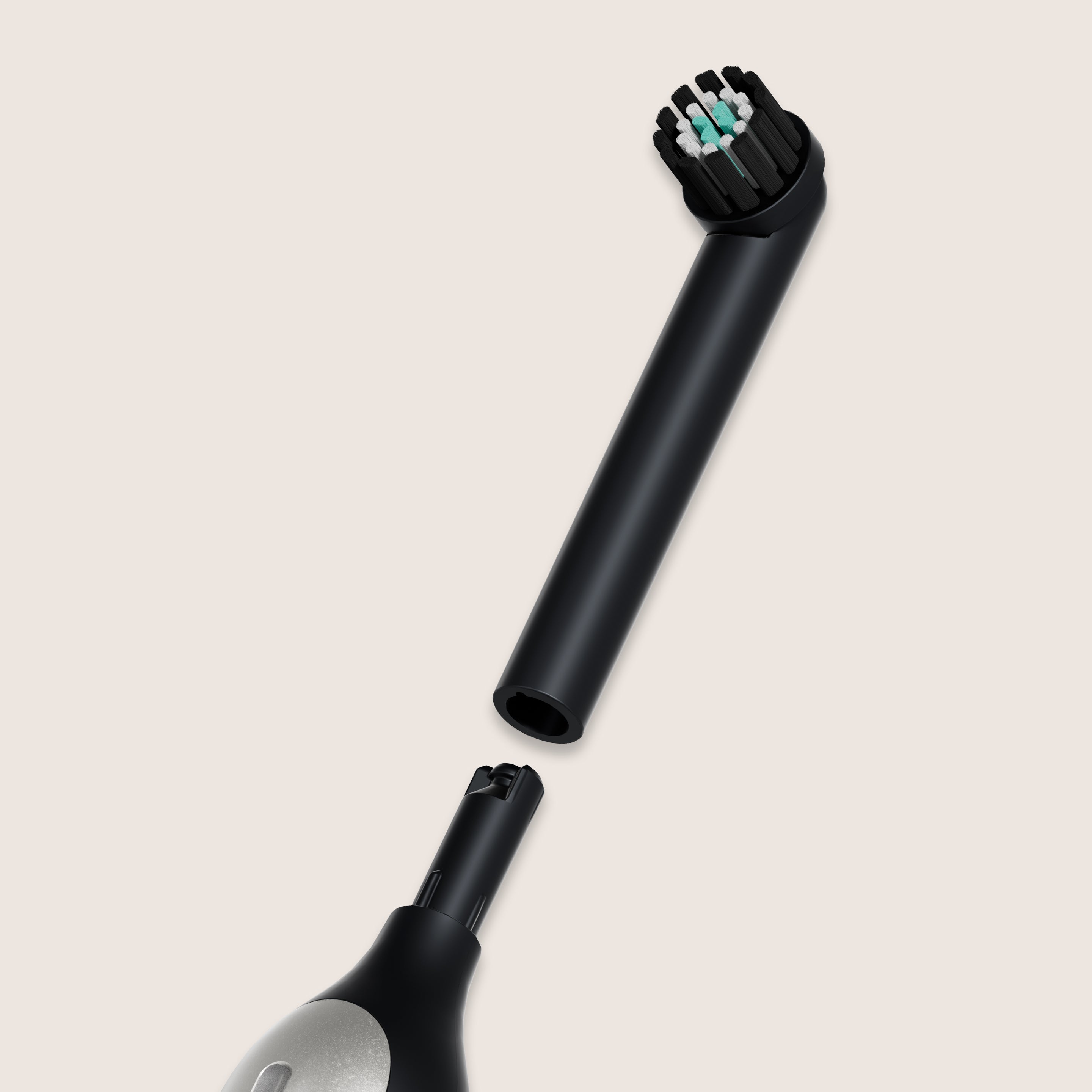 A black quip Rev brush head refill detached from the main body of a black quip electric toothbrush, against a light green background.