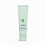 Green tube of quip toothpaste on a white background