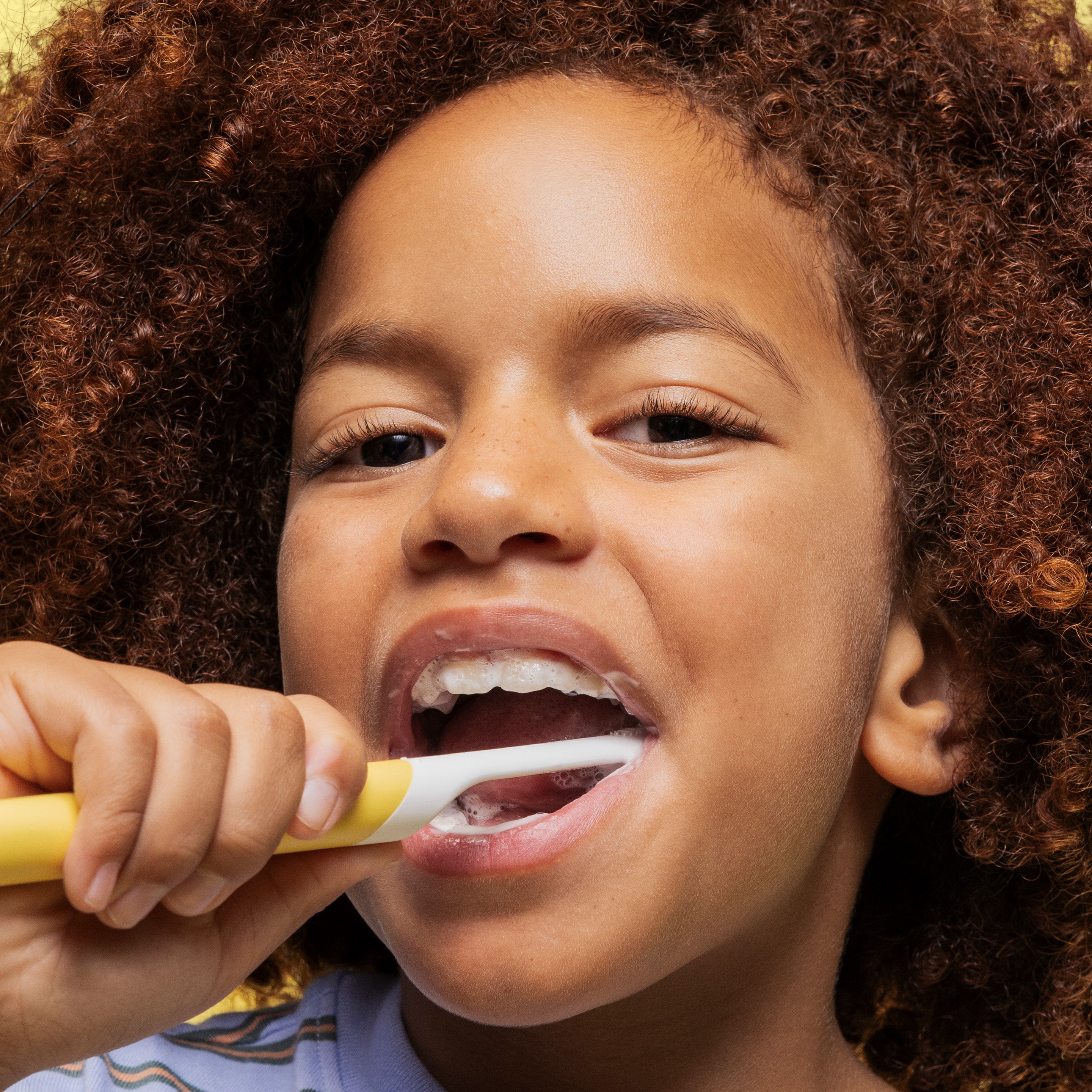 Child brushing their teeth with a close-up focus on the action.