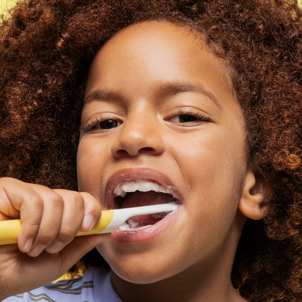 Child brushing their teeth with a close-up focus on the action.