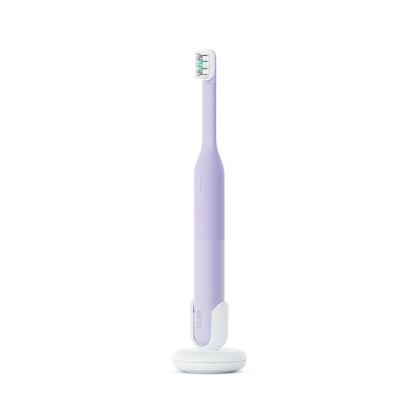 Purple electric toothbrush with white base on a white background