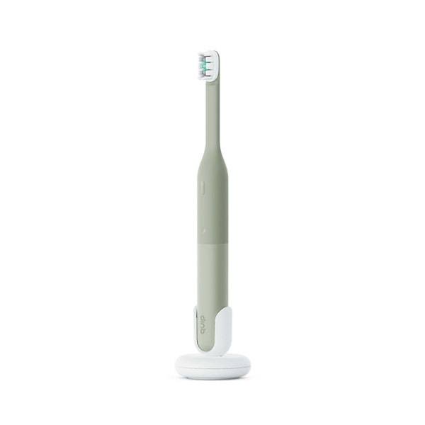 Green electric toothbrush with white base on a white background