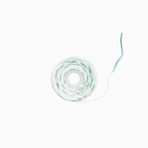 A roll of white cord or twine with a thin mint green stripe running along the outer layer, shown on a clean white background.