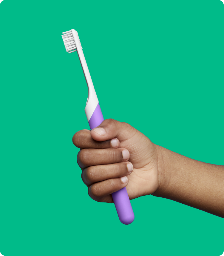 A kid holding quip's kids purple sonic toothbrush