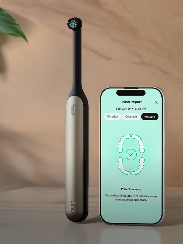Electric toothbrush and smartphone displaying brushing app on a wooden surface