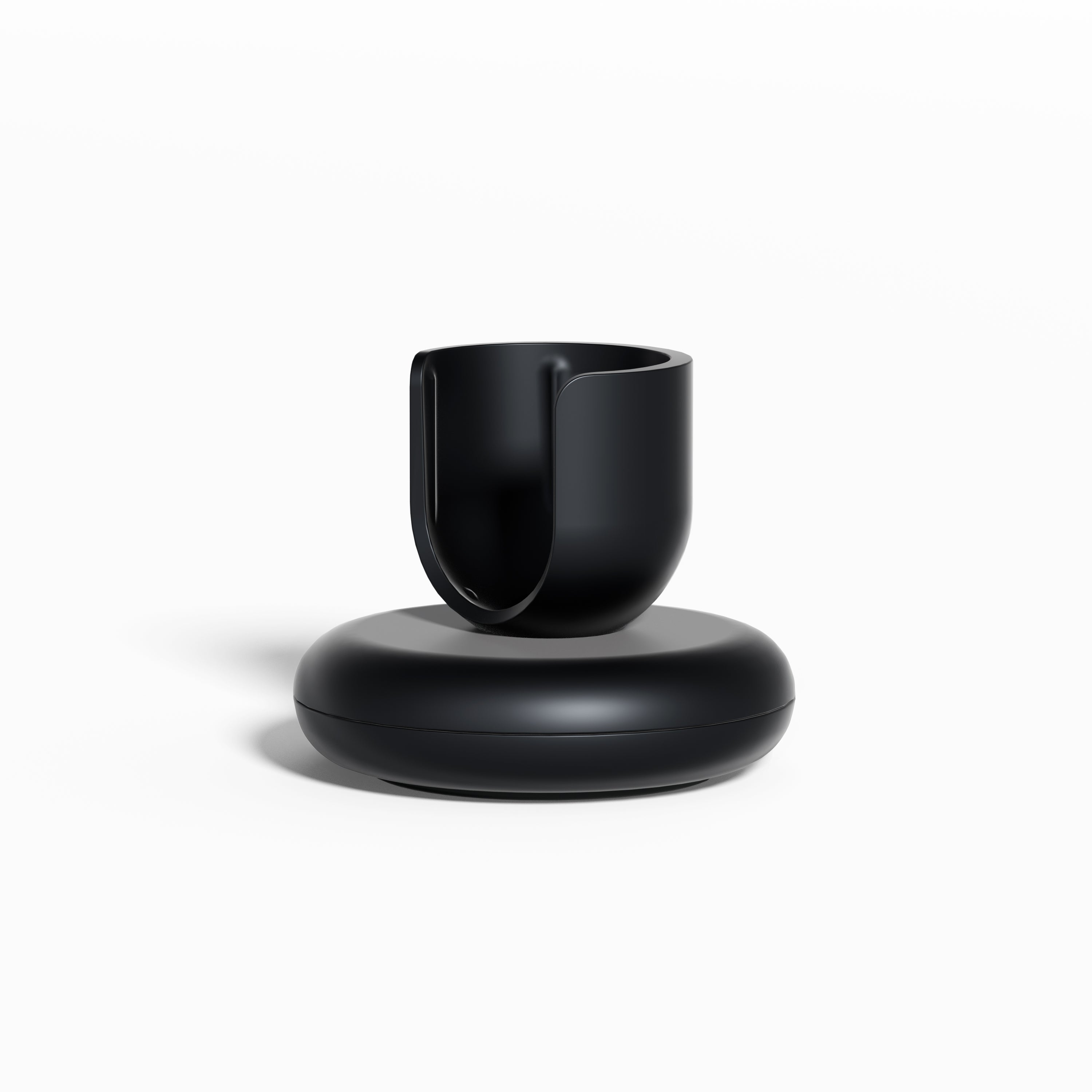 Black Rev Stand featuring a rounded base and an open, U-shaped holder for supporting a toothbrush, shown against a clean white background.